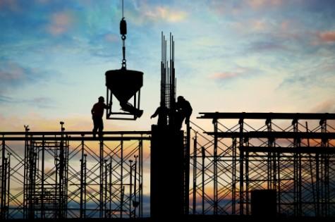 Home 83 Imagem de operários em estrutura de andaimes ao pôr do sol, orientando balde de concreto para concretagem. Ilustra a consultoria PGRCC da Multilix para obras.